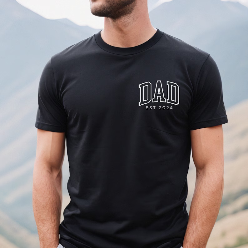 a man wearing a black shirt with the word dad on it